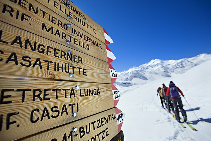 Ski tourers passing trail sign