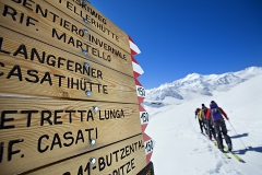 Ski tourers passing trail sign
